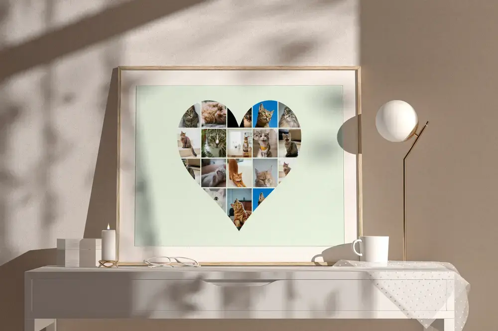 Collage de gatos en corazón sobre fondo verde claro, con marco de madera en un aparador blanco junto a una lámpara
