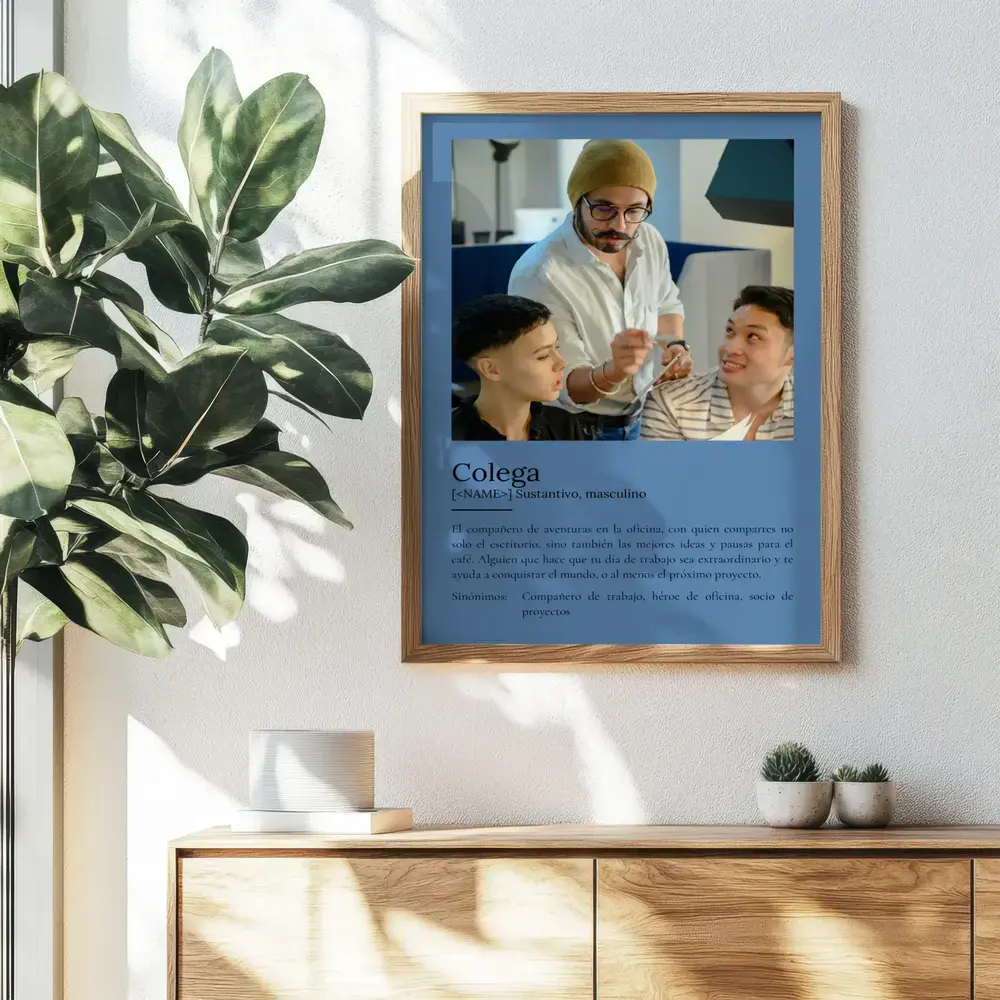Lámina estilo diccionario con foto y fondo azul, enmarcada en madera sobre un aparador junto a una planta