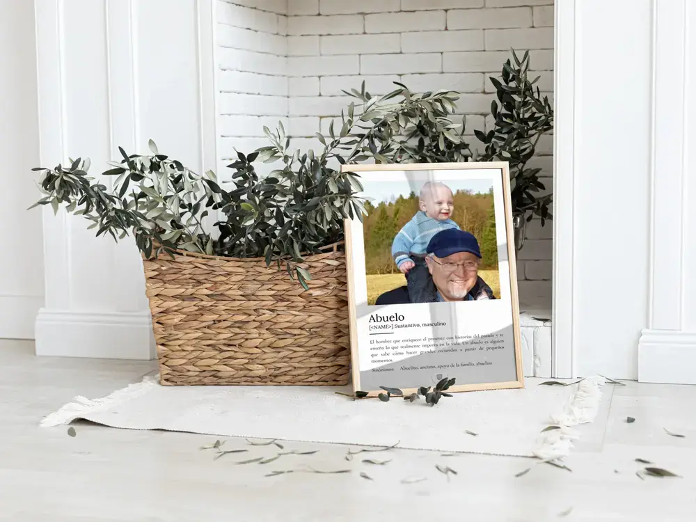 Lámina con foto y definición para regalar al abuelo, apoyada en el suelo junto a una cesta con plantas.