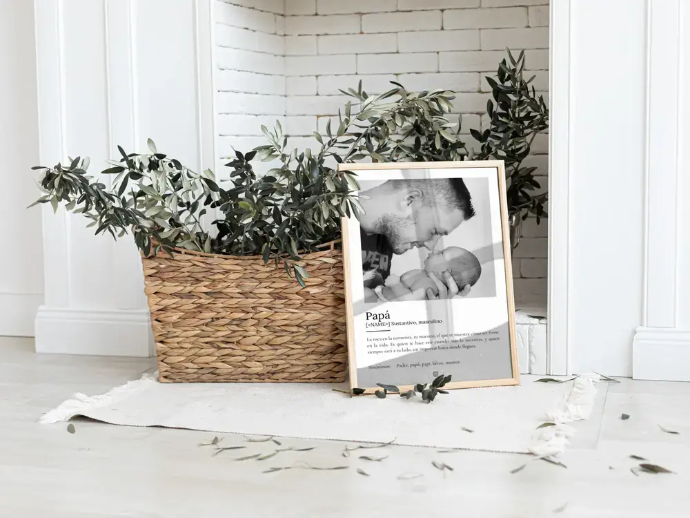 Lámina con definición de padre y foto en blanco y negro, apoyada en el suelo junto a una cesta con plantas