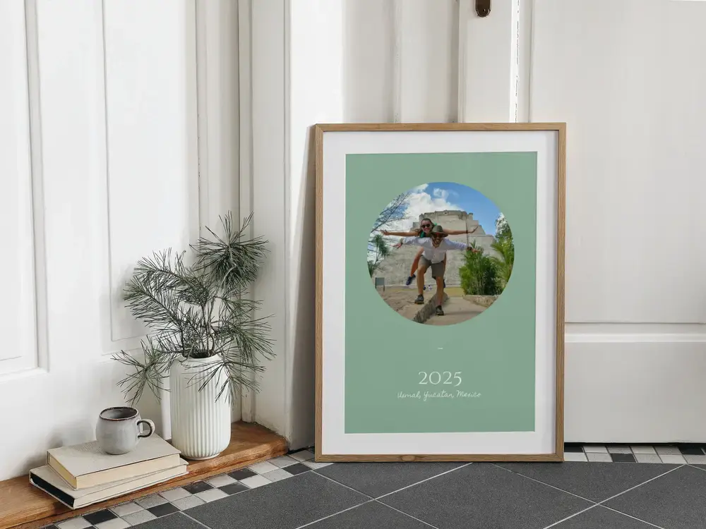 Póster de viaje enmarcado con foto ovalada y fondo verde salvia, apoyado en el suelo, regalo para recordar las vacaciones