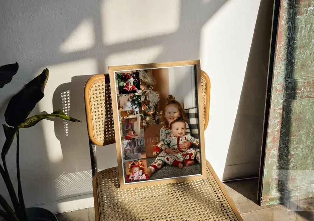 Collage de fotos de Navidad con foto grande de niños y tira lateral, en marco de madera sobre una silla de rejilla